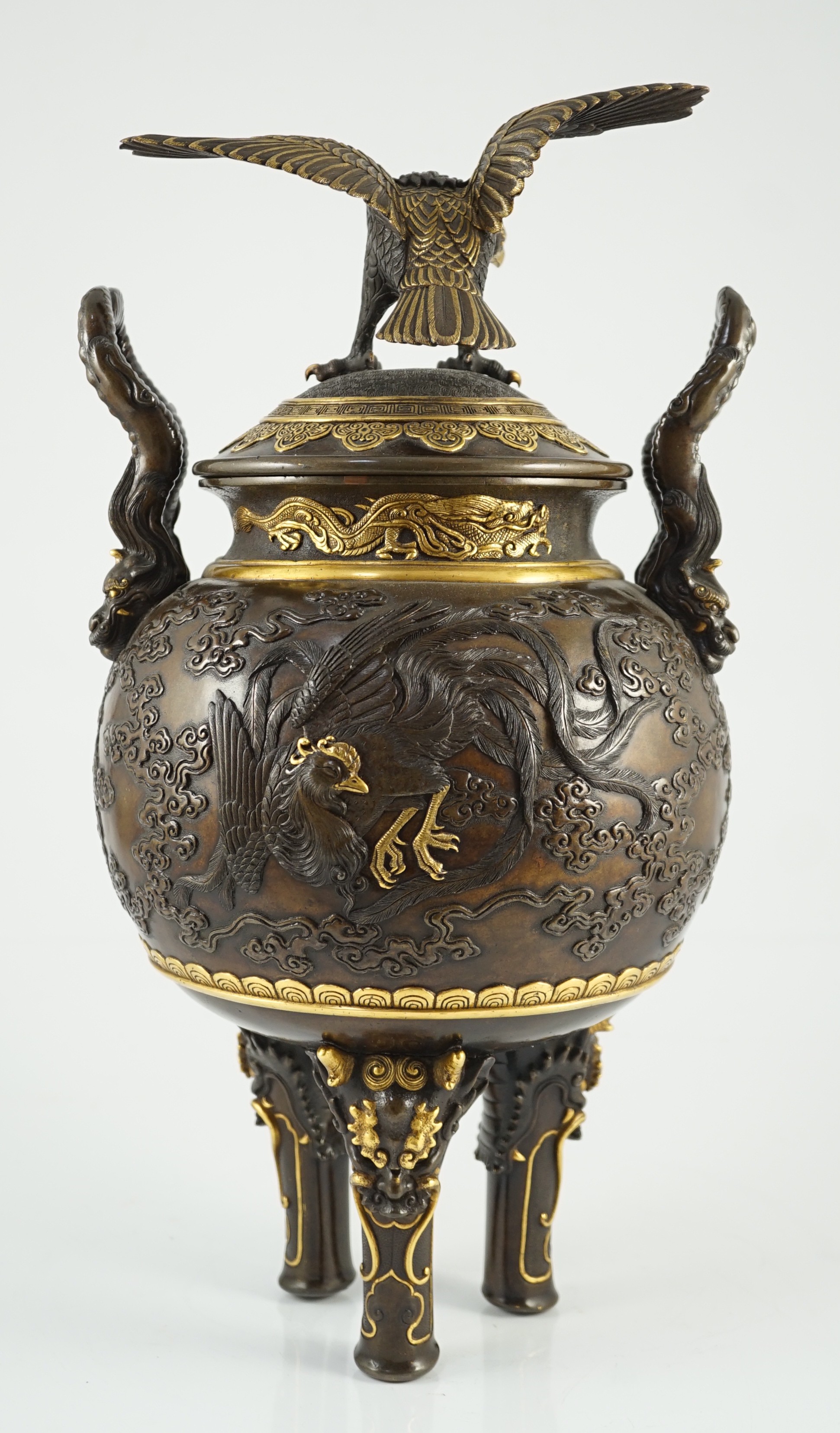 An impressive Japanese brown patinated and gilded bronze tripod koro and cover, by Miyao Eisuke, Meiji period, 42cm high, 23cm wide